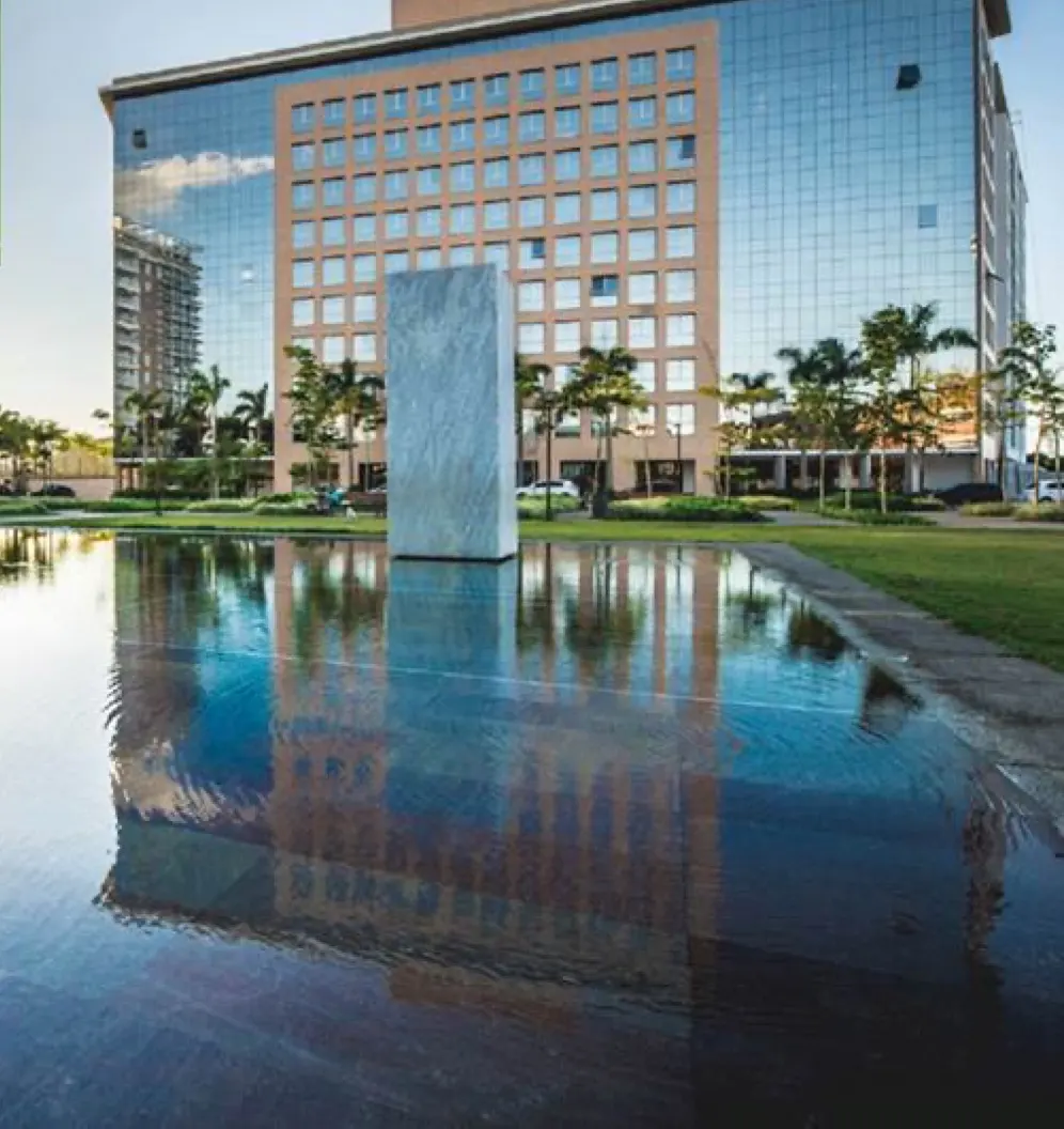 Office Green refletido no espelho d'água da praça